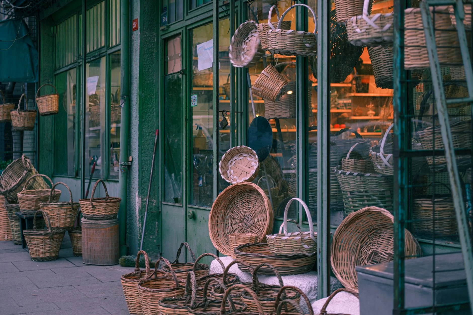 Charming outdoor shop with a display of woven baskets against glass walls.