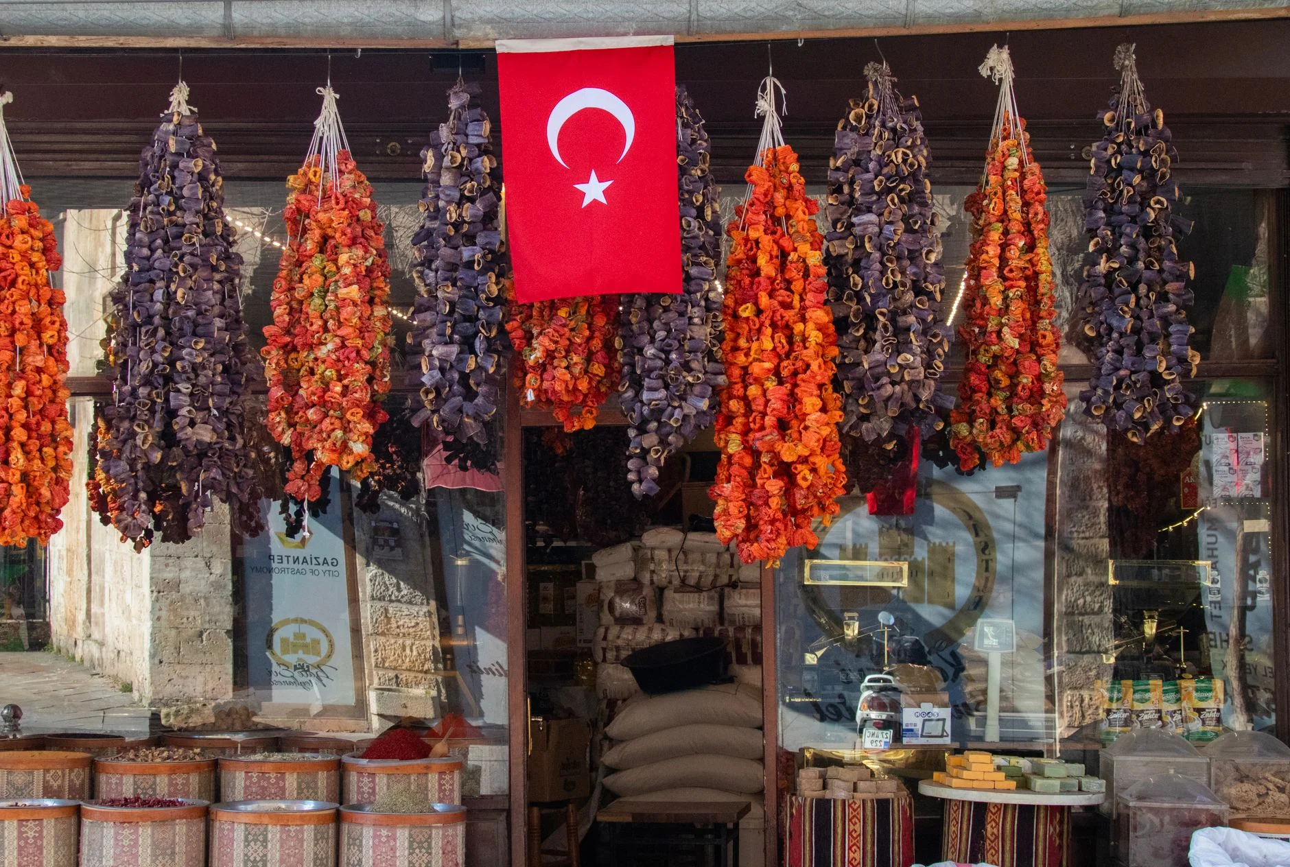 Vibrant dried vegetables and Turkish flag at a market stall in Gaziantep, Turkey.