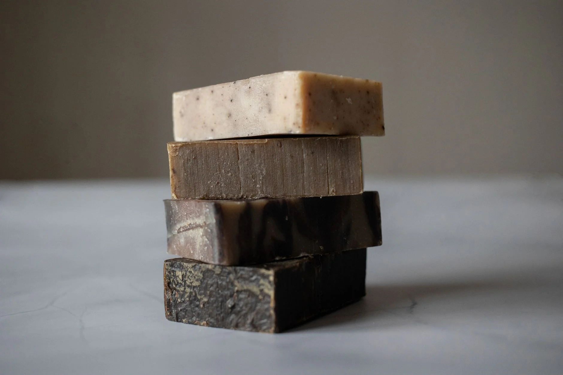 Stack of aromatic natural handmade soaps placed on gray table against blurred background