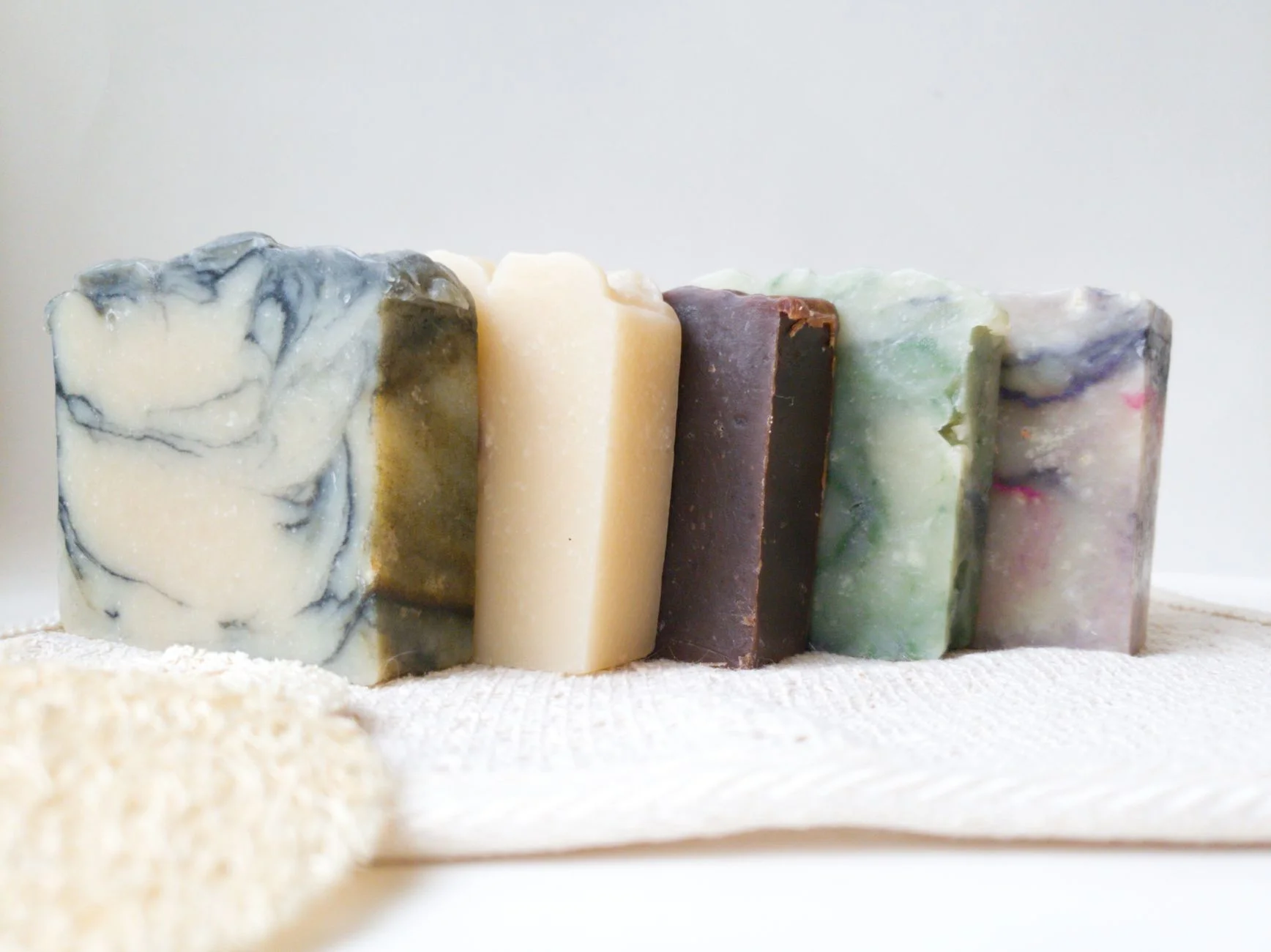 Close-up of various handmade soaps on a textured fabric, showcasing natural beauty and skincare.