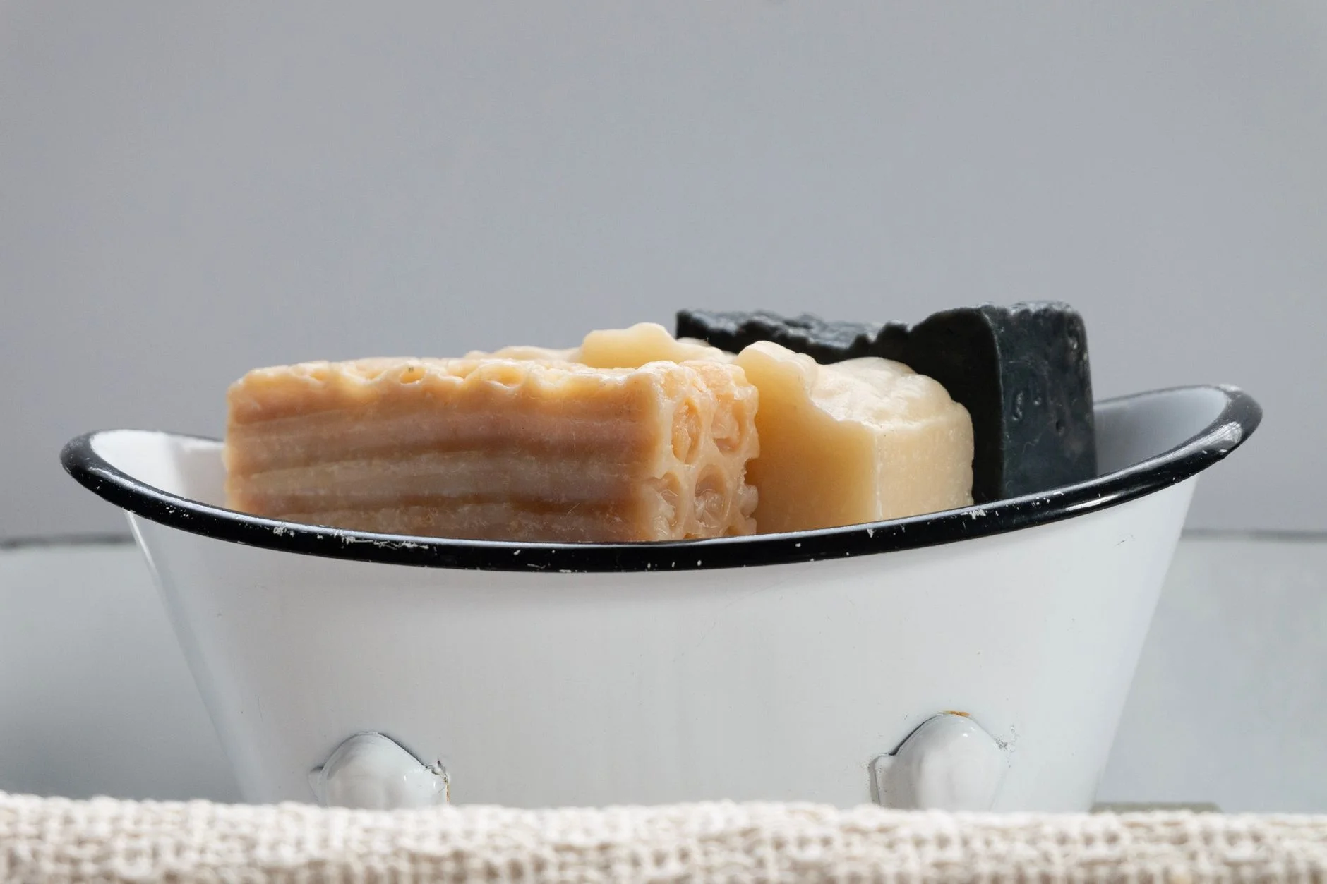 Close-up of assorted handmade soaps in a vintage soap dish.