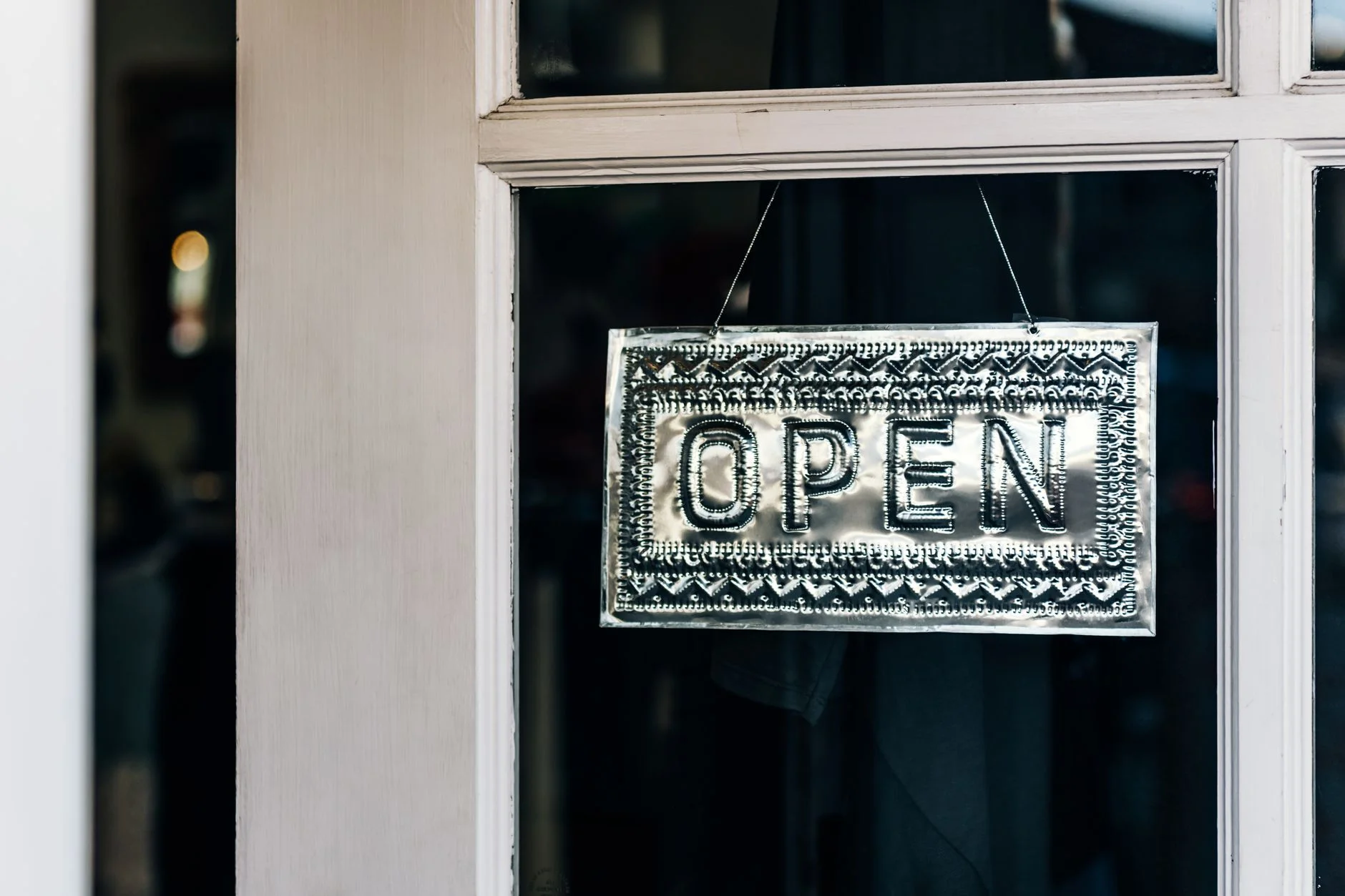 Metal open sign hanging on a shop door in Paso Robles, California.