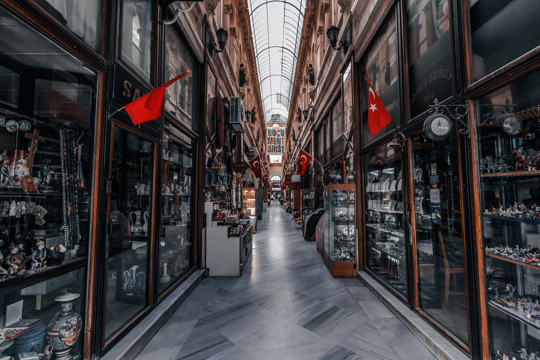 Explore the vibrant covered bazaar in Istanbul's historic Beyoğlu with flags and boutique shops.